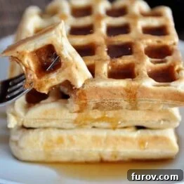 A beautifully stacked image of Overnight Raised Waffles, light and fluffy, ready for breakfast.