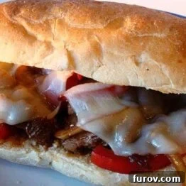 Loaded Steak Hoagies with Sautéed Mushrooms, Onions, and Peppers 3 Close-up of a delicious homemade steak hoagie with melted cheese, onions, mushrooms, and peppers.
