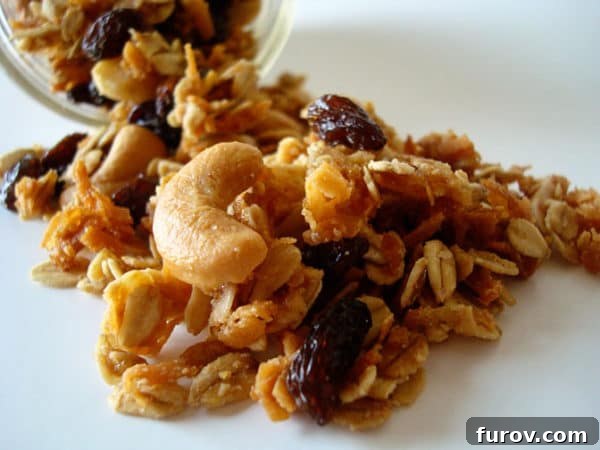 Cashew granola spilling out of a glass mason jar.