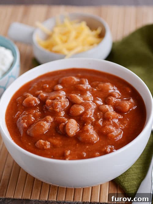 Mom's Hearty Chili: Perfect for Stovetop or Slow Cooker 2 A white bowl of beef and bean red chili, ready to be enjoyed.