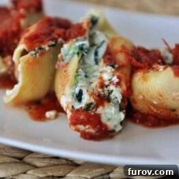 Close-up of Cheesy Spinach Stuffed Shells covered in red sauce.