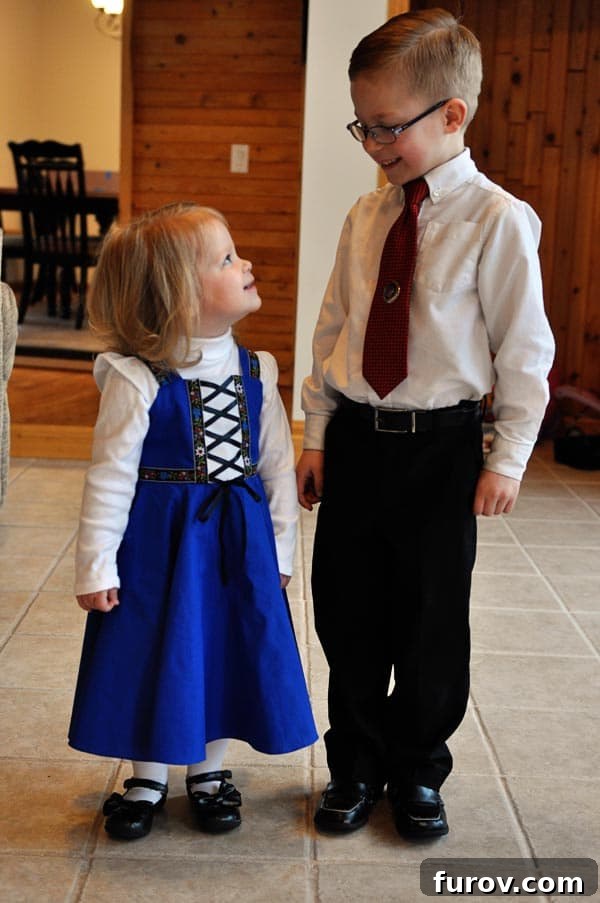 a little boy and girl, dressed in charming church clothes, standing and sharing a loving glance
