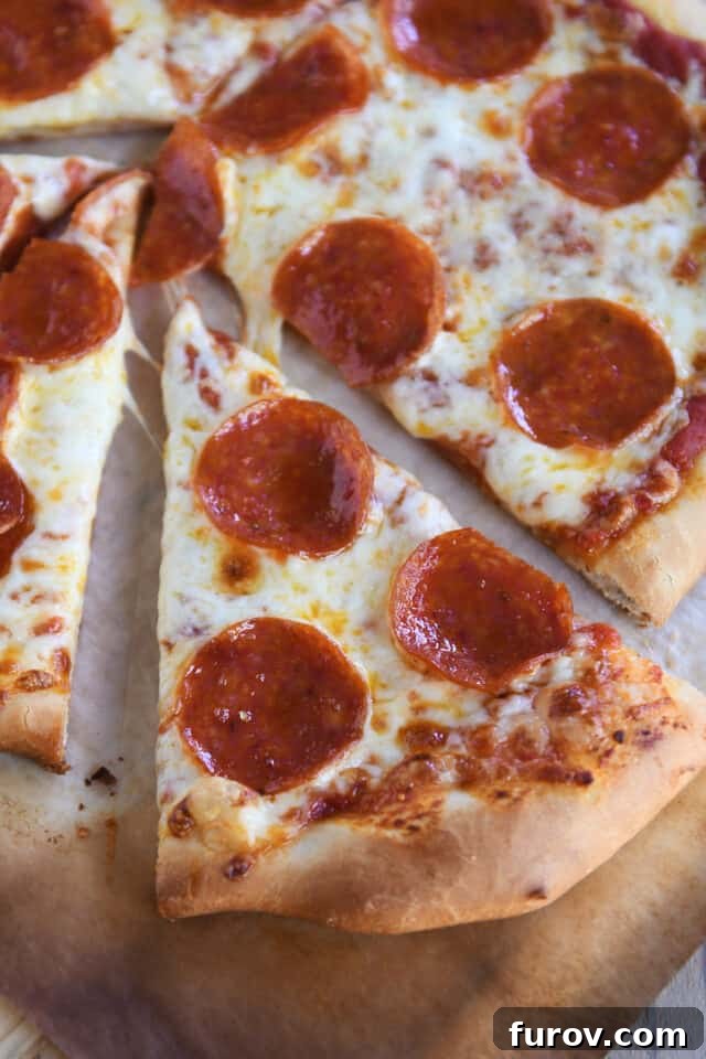 Fast and Flawless Pizza Dough 8 A delectable triangle slice of pepperoni pizza, showcasing the crispy crust and melted cheese.
