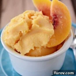 A small white bowl with fresh peach frozen yogurt and a few peach slices, ready to be served.