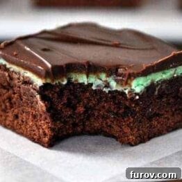 A stack of classic chocolate mint brownies with luscious mint frosting and chocolate ganache