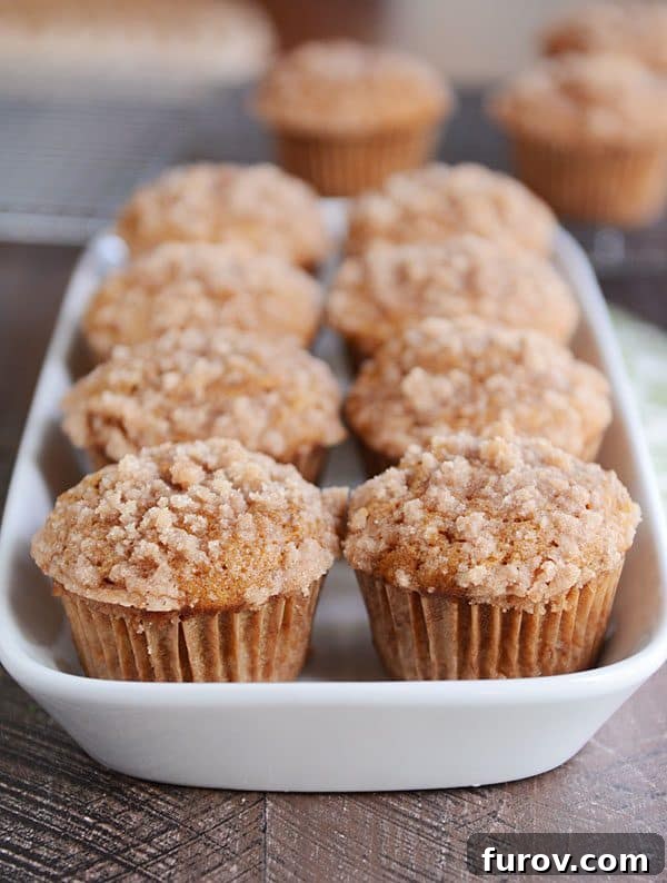 A white dish full of streusel-topped pumpkin muffins, ready to be served.