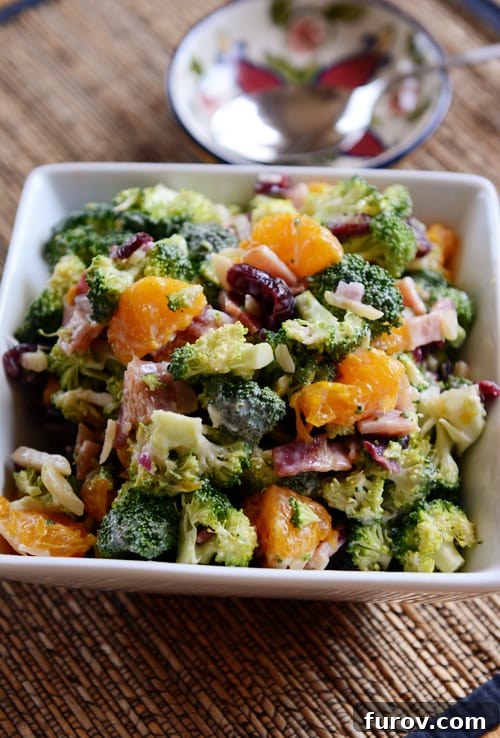 Zesty Mandarin Broccoli Salad 3 Top view of a square white dish full of mandarin broccoli and bacon salad.