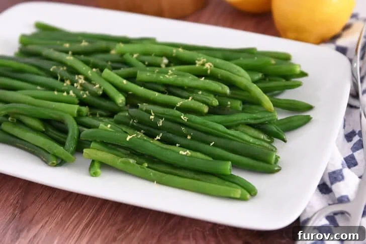 White tray with cooked green beans sprinkled with fresh lemon zest, highlighting a delicious finishing touch for easy skillet green beans.