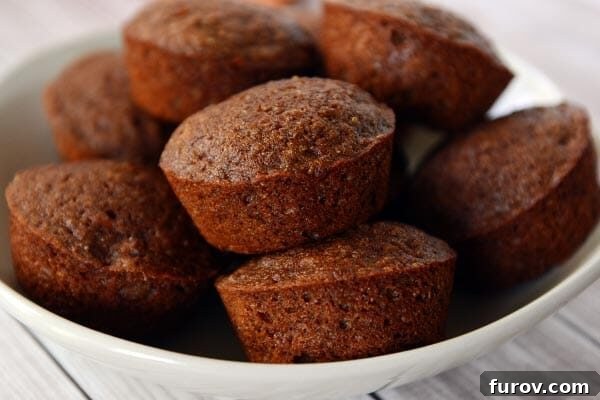 A white plate full of golden brown cooked muffins, ready to be served.