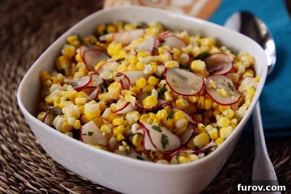 A white bowl full of fresh corn and radish salad, garnished with cilantro.