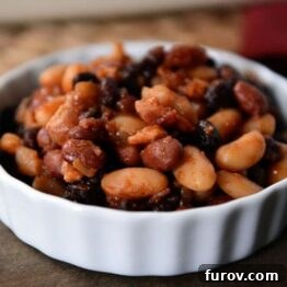 Mom's Legendary Calico Baked Beans 5 A small white ramekin filled with bacon-filled baked beans.