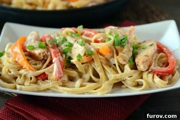 A white platter of cajun chicken pasta.