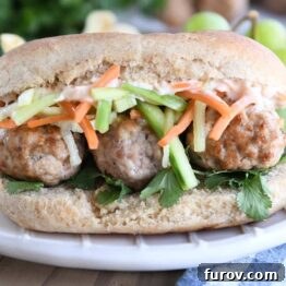 A delicious Banh Mi meatball sub served on a cream plate, garnished with fresh cilantro.