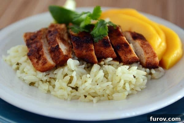 One-Pan Sweet Paprika Chicken 2 Slices of perfectly grilled sweet paprika chicken and sliced ripe mango over a bed of fluffy cilantro lime rice, ready to be served.