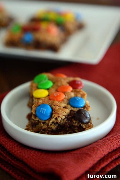A small white ramekin with an M&M topped oat bar inside. 