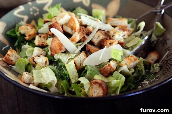 Irresistible Caesar Salad Featuring Homemade Dressing 3 A large, empty salad bowl ready to be filled, next to a smaller bowl of freshly chopped romaine lettuce, awaiting dressing and toppings.