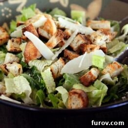 Irresistible Caesar Salad Featuring Homemade Dressing 5 A large bowl full of Caesar salad without dressing, ready for its flavorful accompaniment.