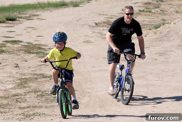A Dad and son riding bikes together.