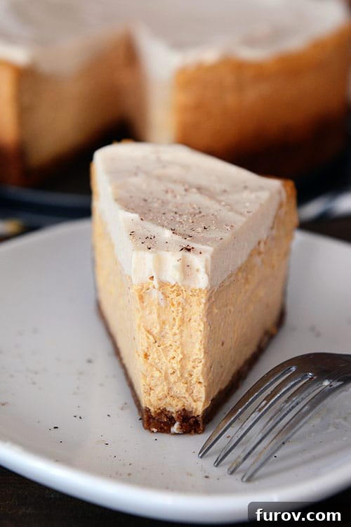 Autumn Delight Pumpkin White Chocolate Mousse Cheesecake Eggless and Gluten-Free Friendly 2 A thick slice of pumpkin cheesecake with a bite taken out on a white plate, showcasing its creamy layers and graham cracker crust.
