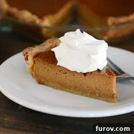 A classic pumpkin pie slice with whipped cream.