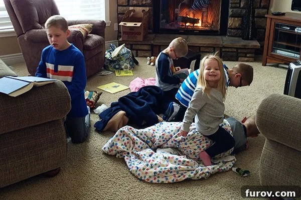 A family, including several children, bundled up and playing in their living room, making the most of a heating outage during winter.
