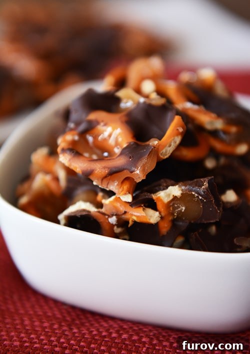 Homemade Dark Chocolate Sea Salt Caramel Pretzel Bark 2 A white bowl full of dark chocolate sea salt caramel pretzel bark pieces, ready to be enjoyed.