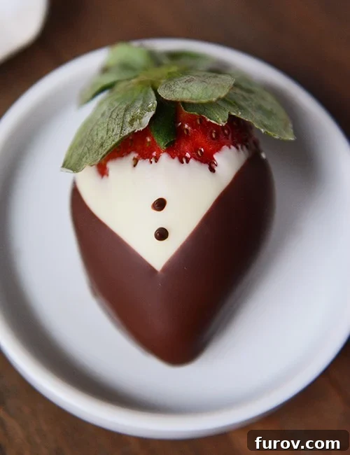 Elegant Tuxedo Strawberries 2 Top view of a tuxedo-style chocolate dipped strawberry with a dark chocolate jacket and white chocolate shirt.