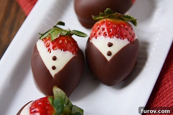 Elegant Tuxedo Strawberries 4 Top view of an arrangement of chocolate dipped strawberries designed to look like little tuxedos, on a white surface.