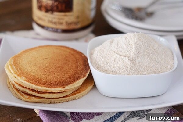 Smart Start Whole Wheat Pancake Mix 3 A stack of golden brown, cooked whole wheat pancakes next to a bowl of ground wheat.