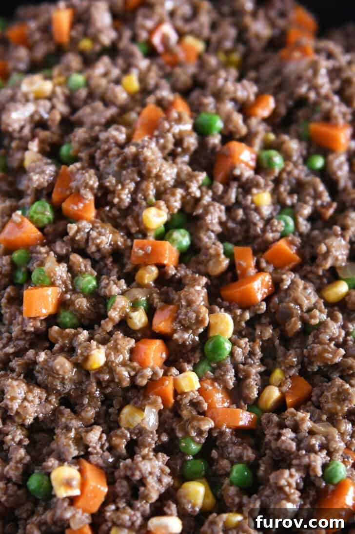 Rustic Meat and Potato Pie 3 Close-up, top-down view of a beautifully cooked ground beef and vegetable mixture, rich in color and texture, ready for the pie.