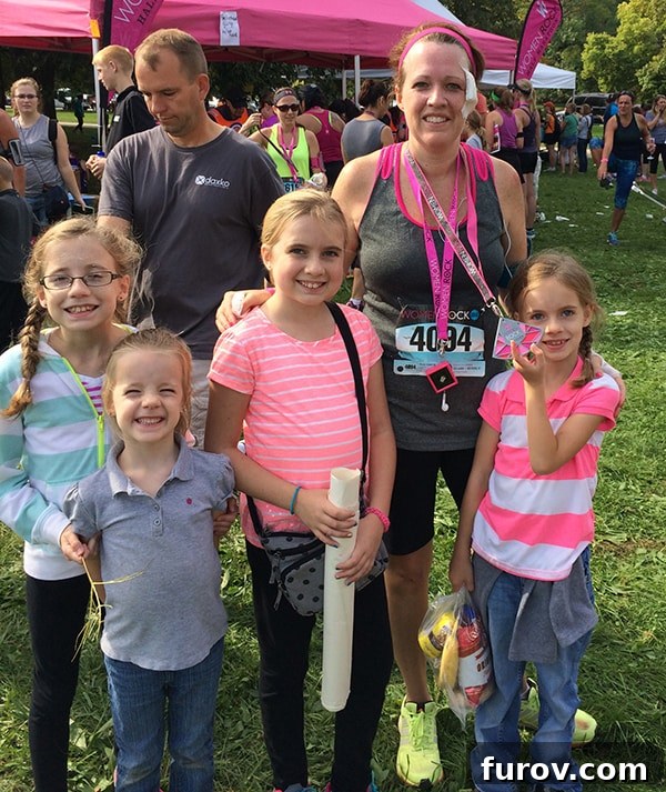 Rachael with her children after completing her first half marathon, showing a large bandage on her face