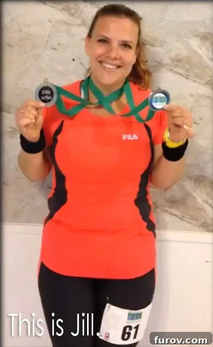 a woman holding up two running medals hung around her neck.