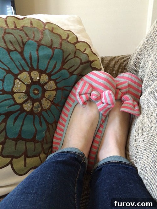 Feet with striped pink and gray slippers.