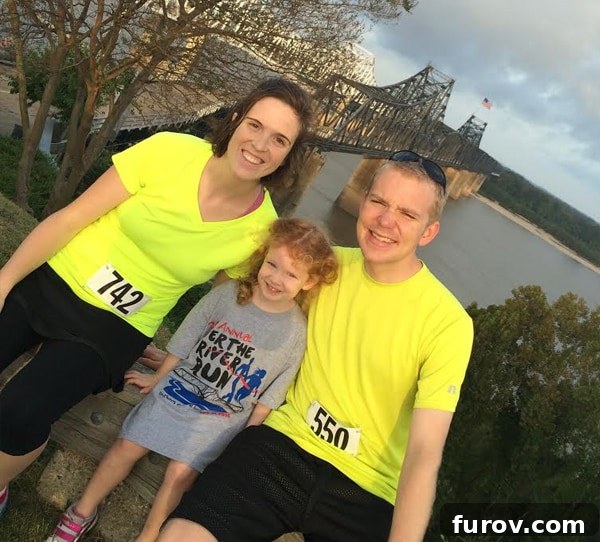 A family smiling after a run, standing in front of a bridge over a river, embodying the joy of running together.
