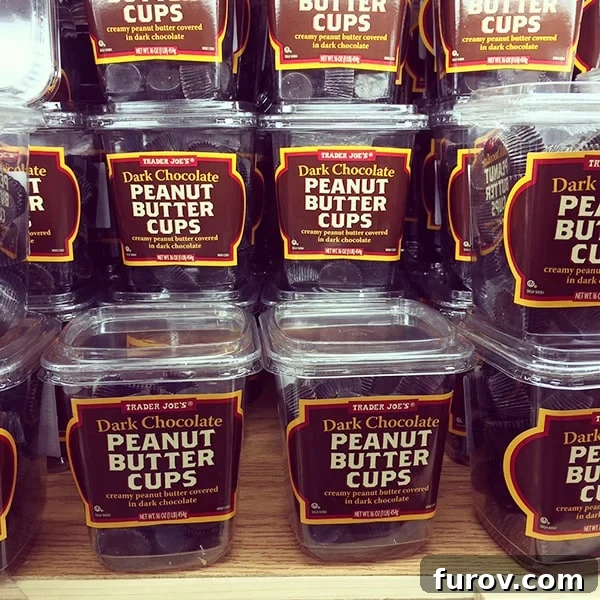 A big stack of Trader Joe's containers of dark chocolate peanut butter cups. 