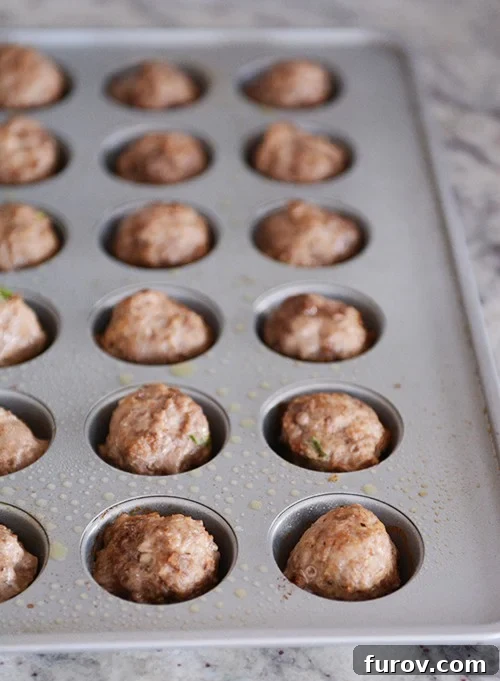 Sweet & Savory Orange Glazed Meatballs 4 Cooked meatballs in a mini muffin tin.