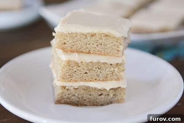 A stack of beautifully iced banana bars on a clean white plate, ready to be enjoyed.