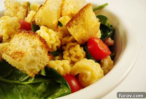 Savory BLT Pasta 3 White bowl with fresh tomatoes, tender pasta, vibrant spinach, and crispy croutons, ready to be served.