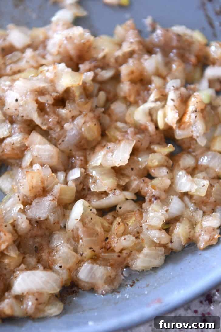 A skillet full of sautéed onions, perfectly golden and translucent, ready for the next step.