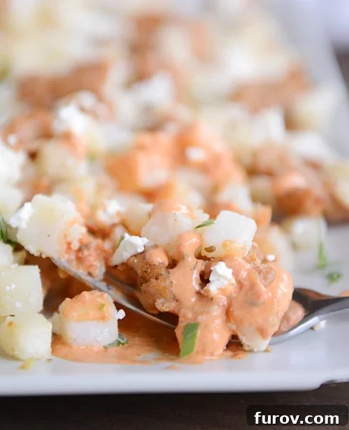 Vibrant Pesto Roasted Pepper Hash Browns 3 A white tray full of cubed potatoes covered in a red pepper sauce.