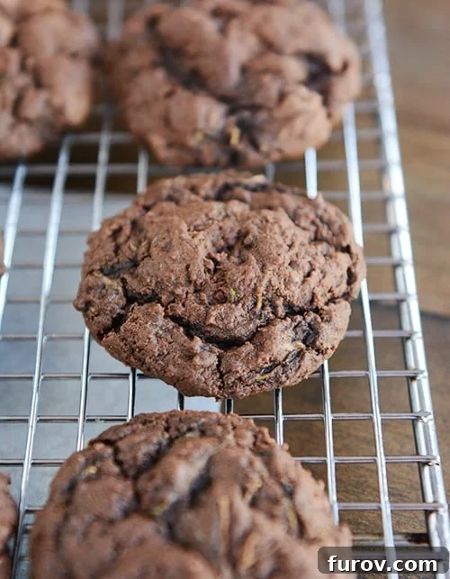 Freshly baked Triple Chocolate Zucchini Cookies cooling on a wire rack.