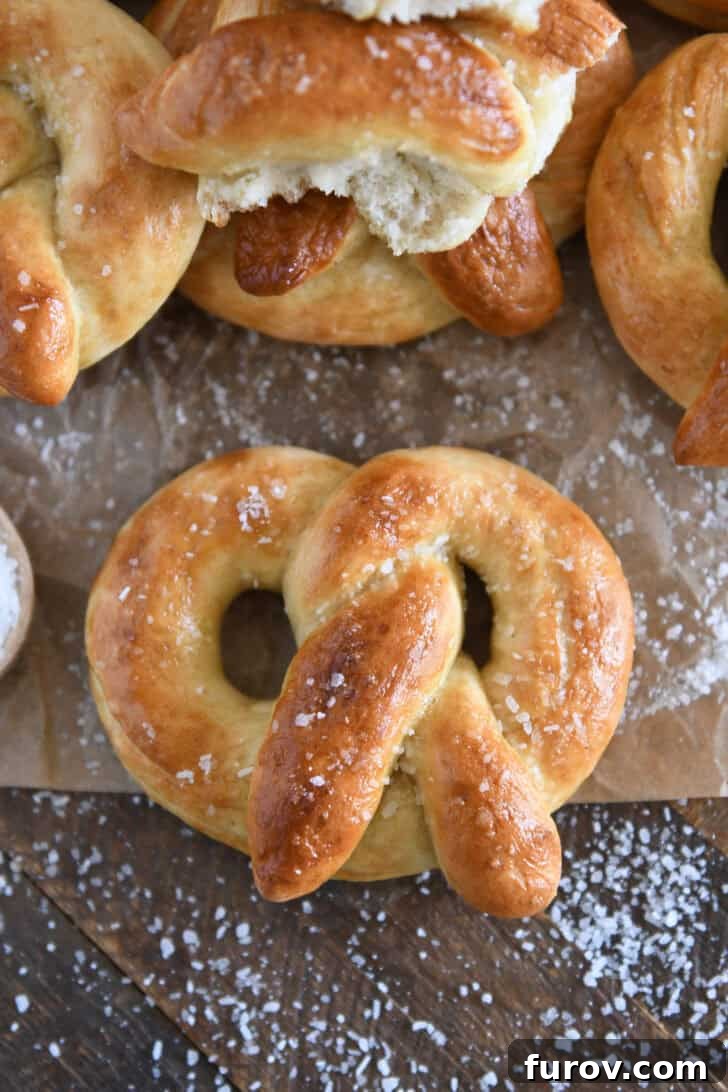 Pillowy Soft Homemade Pretzels 12 A top-down view of a beautifully baked and buttered soft homemade pretzel, generously sprinkled with coarse salt.
