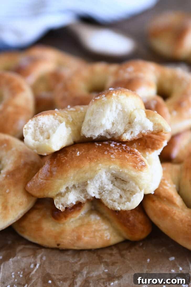 Pillowy Soft Homemade Pretzels 13 Two halves of a soft pretzel torn apart to reveal its tender interior, stacked enticingly on top of several other homemade soft pretzels.