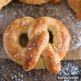 Pillowy Soft Homemade Pretzels 14 A top-down view of a beautifully baked and buttered soft homemade pretzel, generously sprinkled with coarse salt.