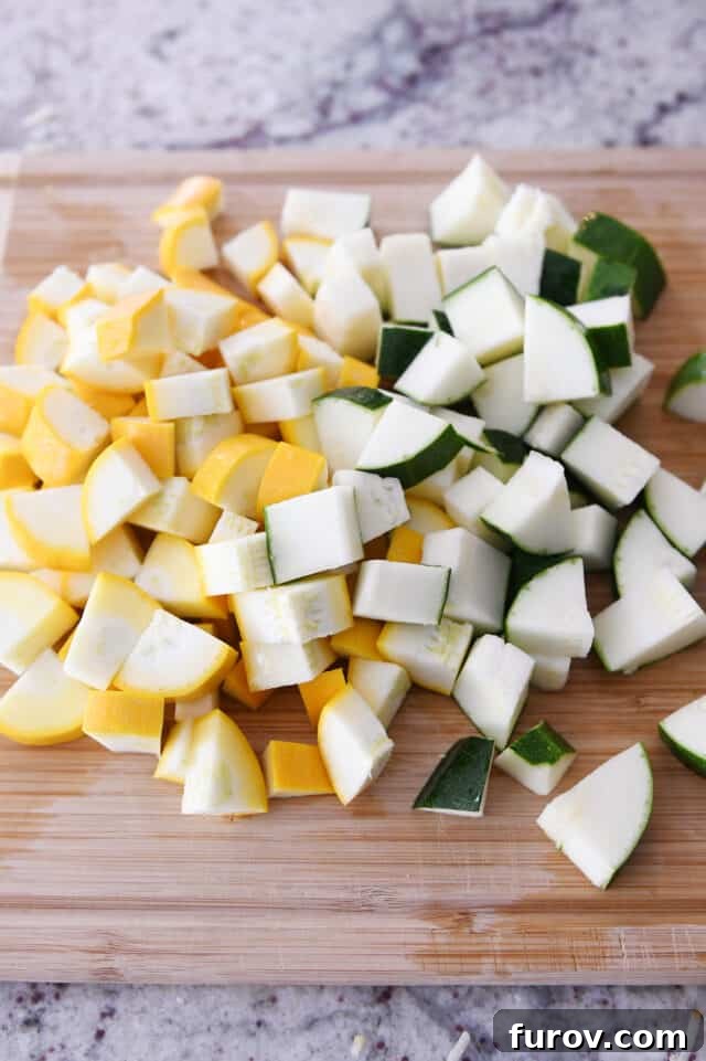 Cutting board with chopped zucchini and yellow squash.