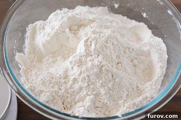 A clear bowl full of white flour.