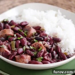 Hearty Slow Cooker Red Beans and Rice with Chicken Sausage 5 Red beans and sausage next to cooked white rice in a large bowl.