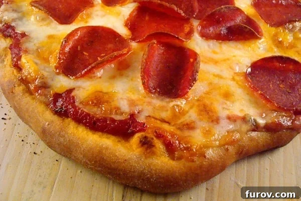 Top-down view of a cooked pepperoni and cheese pizza, showcasing the melted cheese and crispy crust.