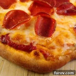 Top view of a cooked pepperoni and cheese pizza.