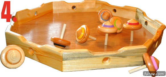 Close-up of the wooden game board and spinning tops for Battle of the UFOs, a handcrafted game.
